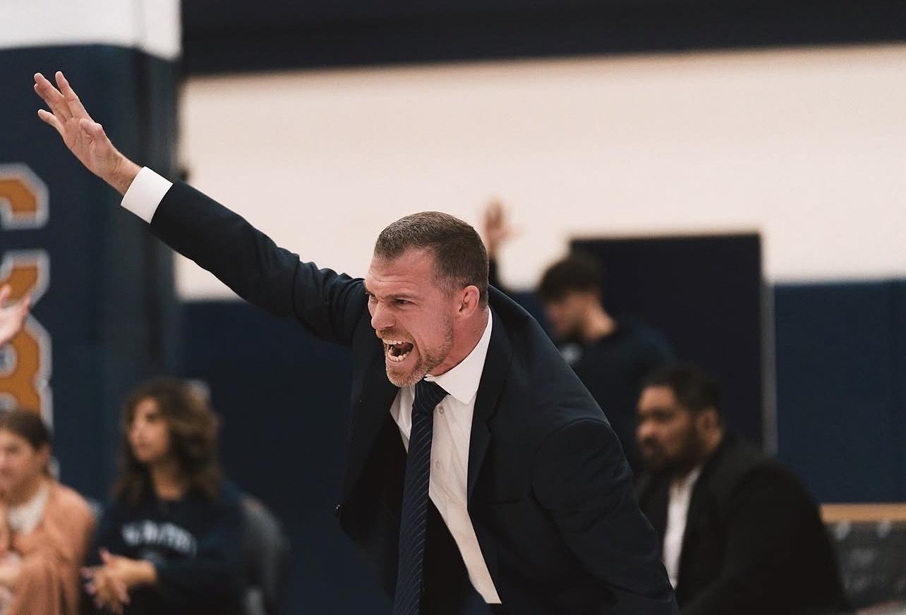 Derek Moore coaching from mat-side during a match